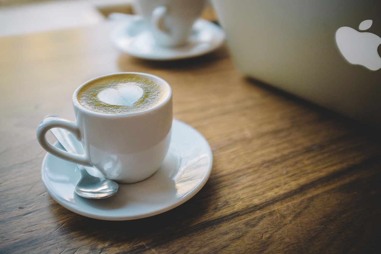 机の上のコーヒーとノートパソコン