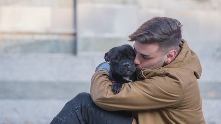 犬を抱く男性